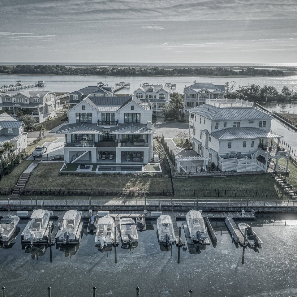Drone aerial of waterfront coastal homes with marina docks — architectural photography for builders by Lifted Pictures