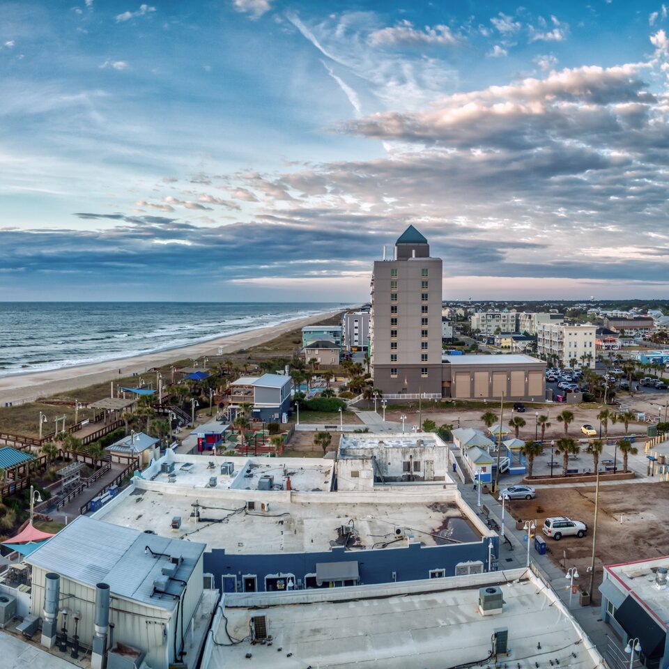 Elevated coastal resort photograph showing beachfront hotel, boardwalk, and ocean at golden hour — resort photography by Lifted Pictures