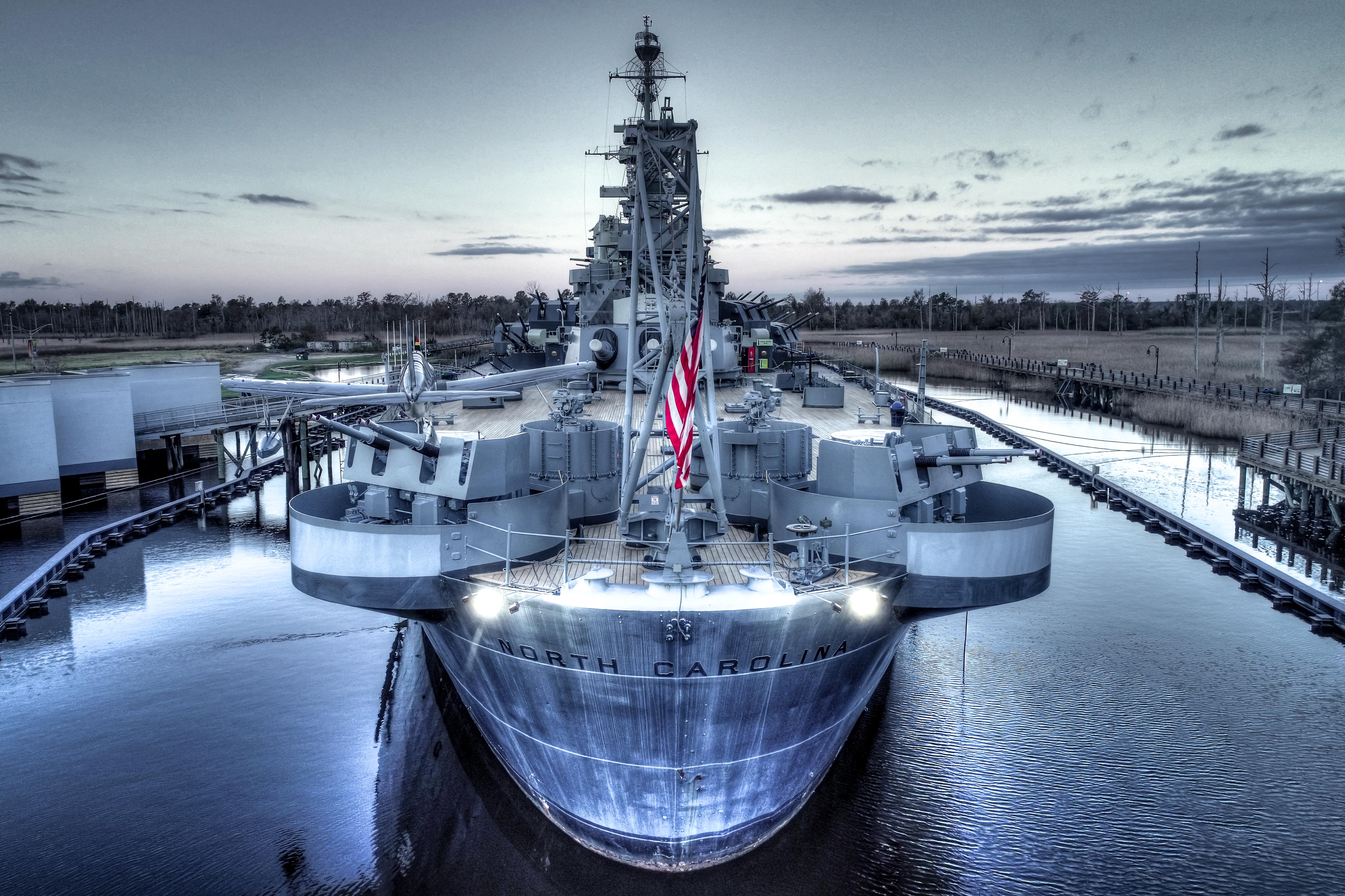 Head-on aerial view of Battleship North Carolina at twilight