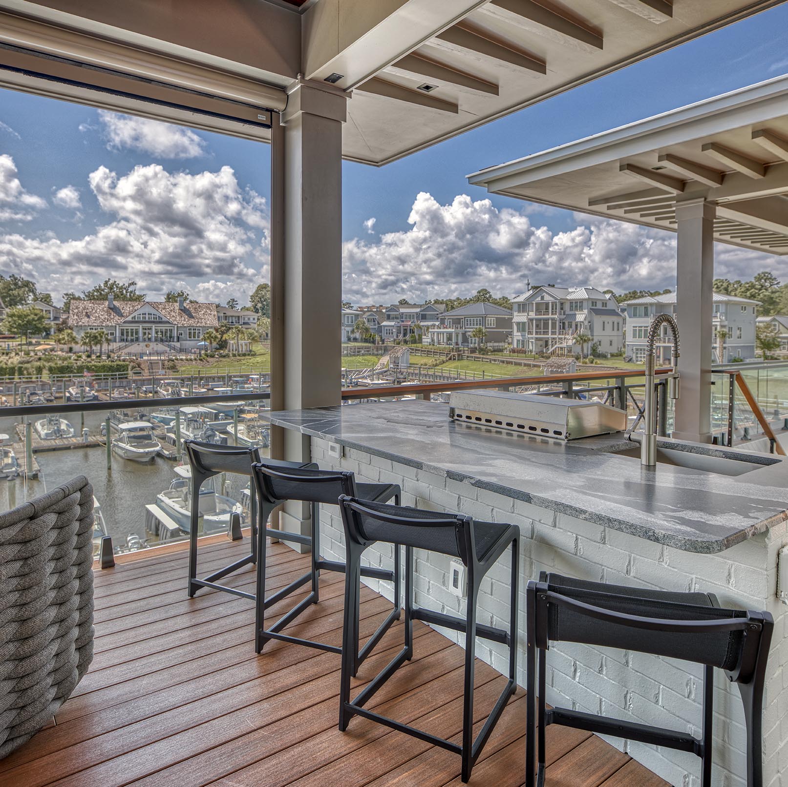 Coastal home outdoor kitchen and terrace overlooking a marina
